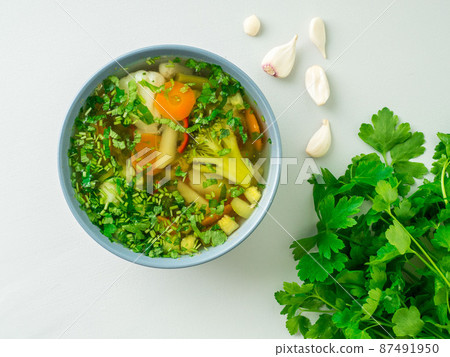 Healthy spring vegetable dietary vegetarian soup, gray concrete background, top view, close up. 87491950