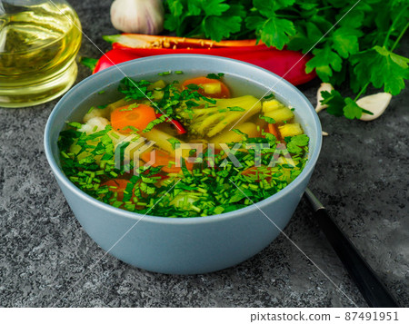 Healthy spring vegetable dietary vegetarian soup, gray concrete background, side view, close up. Healthy spring vegetable dietary vegetarian soup, gray concrete background, side view, close up. 87491951