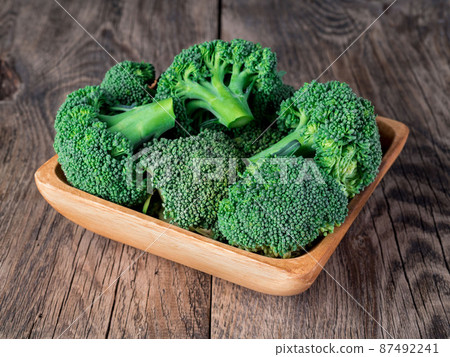 fresh raw green broccoli in wooden bowl on wooden background 87492241