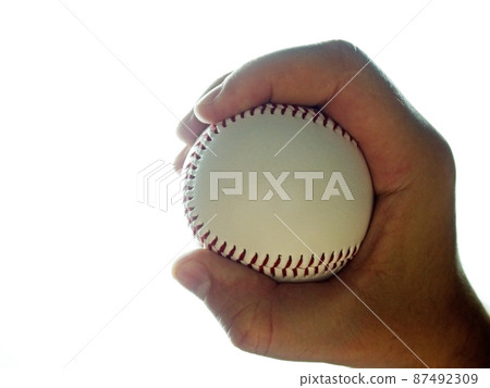 Baseball ball in male hand on white background Baseball ball in male hand on white background 87492309