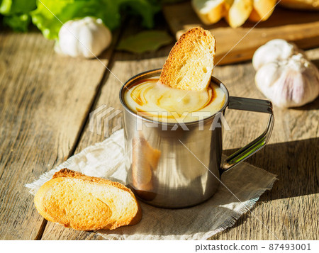 Simple diet is not fatty food, a small portion of cream soup mashed potatoes and cabbage in a metal mug, croutons. Side view, selective focus, daylight. 87493001
