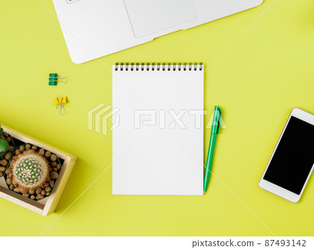 Top view of modern bright yellow office desktop with blank notepad, computer, smartphone. Mock up, empty space Top view of modern bright yellow office desktop with blank notepad, computer, smartphone. Mock up, empty space 87493142