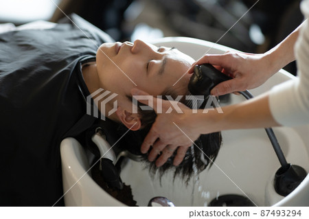 A man who gets shampooed at a beauty salon A man who gets shampooed at a beauty salon 87493294
