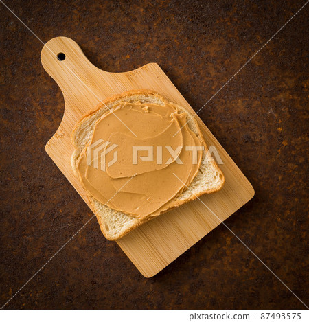 Peanut Butter on Toast. Old rusty metal dark background, top view. 87493575