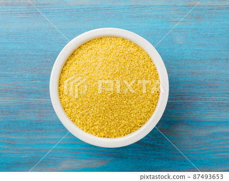 White bowl with raw couscous on blue wooden background, top view. Traditional Moroccan food White bowl with raw couscous on blue wooden background, top view. Traditional Moroccan food 87493653