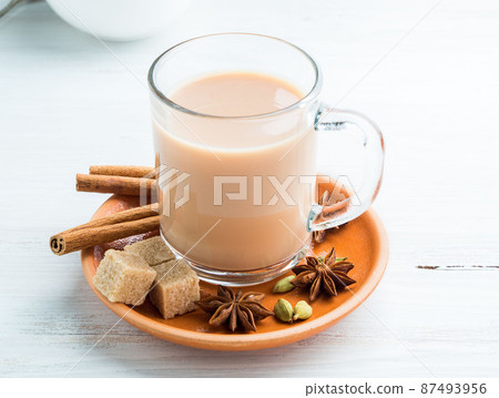 Masala Indian drink in the festival of Holi. Tea with milk and spices in a glass mug. Masala Indian drink in the festival of Holi. Tea with milk and spices in a glass mug. 87493956