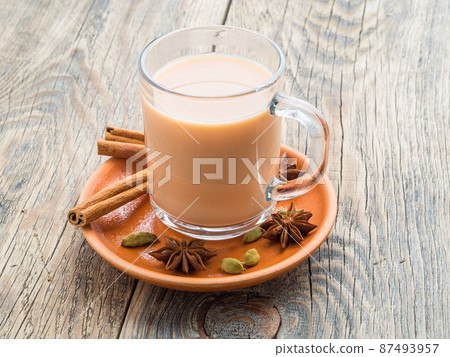Masala Indian drink in the festival of Holi. Tea with milk and spices in a glass mug. Masala Indian drink in the festival of Holi. Tea with milk and spices in a glass mug. 87493957