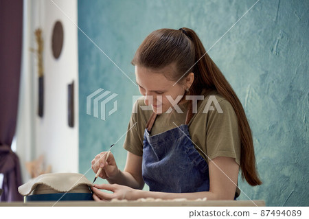Young girl making ceramic bowl in class. Creative hobby concept Young girl making ceramic bowl in class. Creative hobby concept 87494089