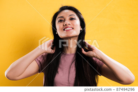 Happy young woman in the studio against a yellow background Happy young woman in the studio against a yellow background 87494296