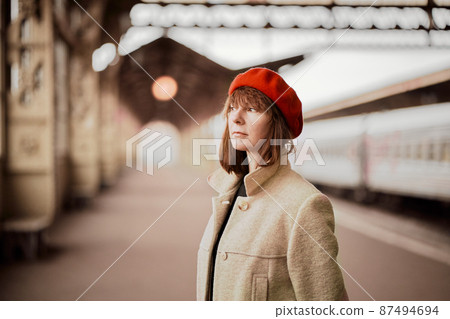 Close up portrait of beautiful woman, smiling and waiting for train on railway station. Girl travels light Close up portrait of beautiful woman, smiling and waiting for train on railway station. Girl travels light 87494694