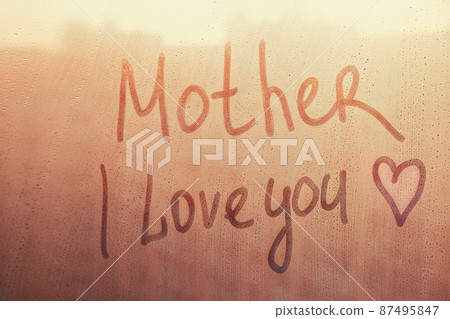 Text Mother i love you written finger with heart shape on orange sunset wet window Text Mother i love you written finger with heart shape on orange sunset wet window 87495847