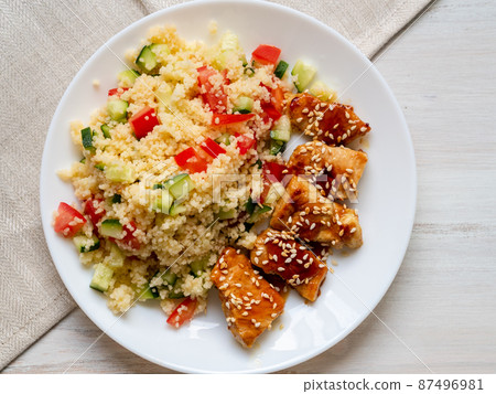 Turkey meat, fried, with teriyaki sauce and sesame seeds. Couscous with vegetables. Selective focus, day natural light 87496981
