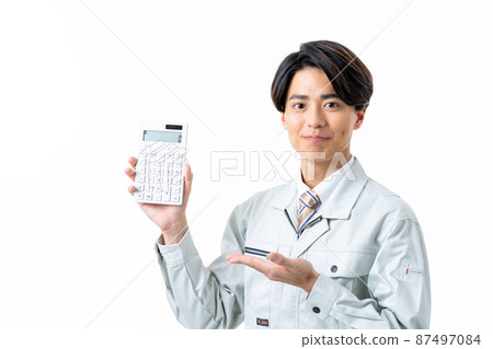 一個年輕的男工，白色背景上有計算器 87497084