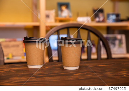 放在桌上熱飲上的紙杯 87497925