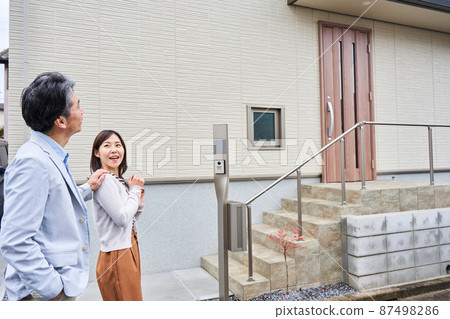 一對夫婦站在他們家門前 87498286