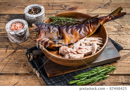 Fillet of Hot smoked fish pike perch or zander in a wooden plate with herbs. wooden background. Top view Fillet of Hot smoked fish pike perch or zander in a wooden plate with herbs. wooden background. Top view 87498425