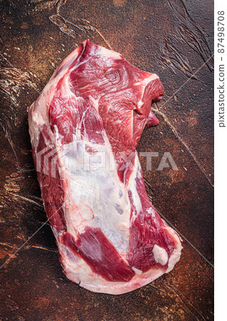 Raw lamb mutton shoulder meat on the bone. Dark background. Top view Raw lamb mutton shoulder meat on the bone. Dark background. Top view 87498708