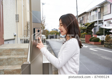 Woman pushing the intercom 87499124