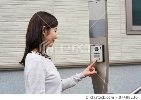 Woman pushing the intercom 87499130