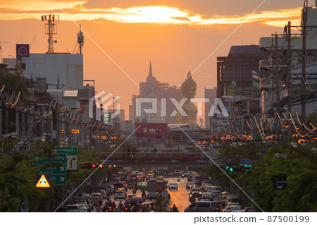 Aerial view of the Giant Golden Buddha in Wat Paknam Phasi Charoen Temple with cars on traffic street road in Phasi Charoen district, Bangkok. Urban town, Thailand. Downtown City. 87500199