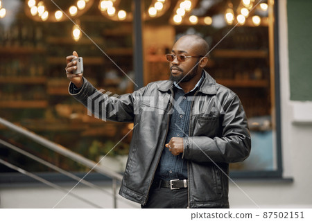Black man standing on a street and making a selfie 87502151
