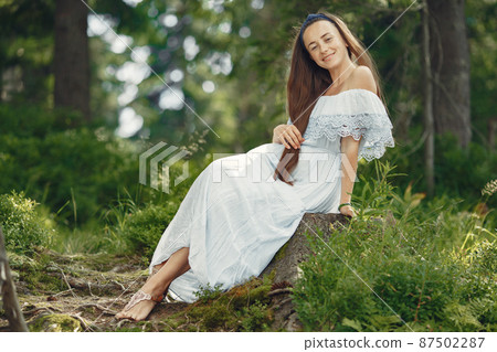 Stylish woman spending time in a summer forest 87502287