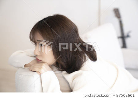 Woman thinking on the sofa Woman thinking on the sofa 87502601