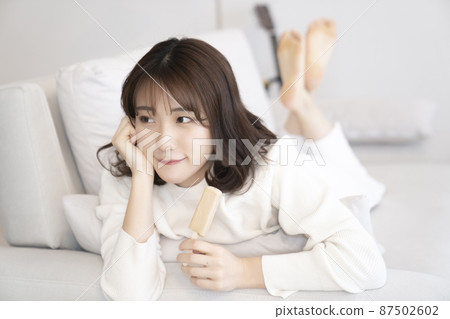 在沙發上吃冰淇淋的女人 在沙發上吃冰淇淋的女人 87502602