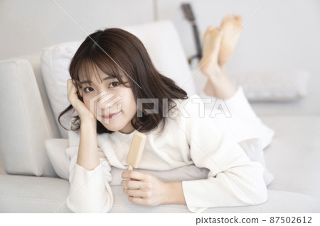 在沙發上吃冰淇淋的女人 在沙發上吃冰淇淋的女人 87502612