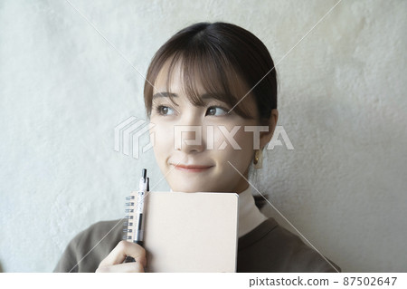 A woman with a note and a pen 87502647