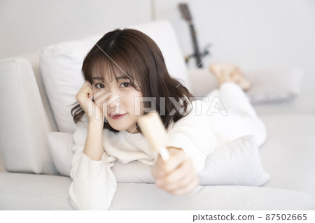 Woman eating ice cream on the sofa 87502665