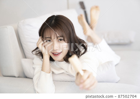Woman eating ice cream on the sofa 87502704