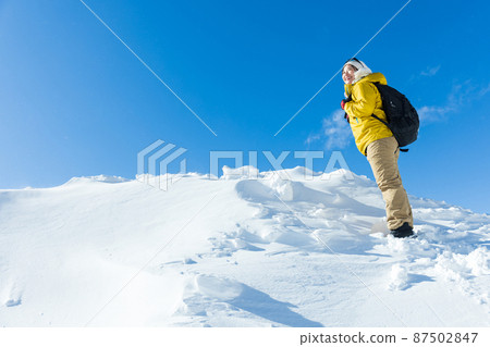 A woman enjoying snowy mountain climbing A woman enjoying snowy mountain climbing 87502847