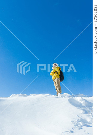 A woman enjoying snowy mountain climbing A woman enjoying snowy mountain climbing 87502852