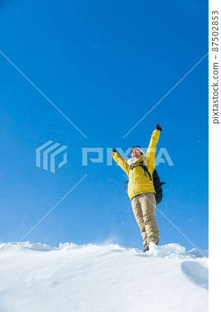 A woman enjoying snowy mountain climbing 87502853