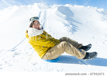 Cute woman enjoying sledding 87502871