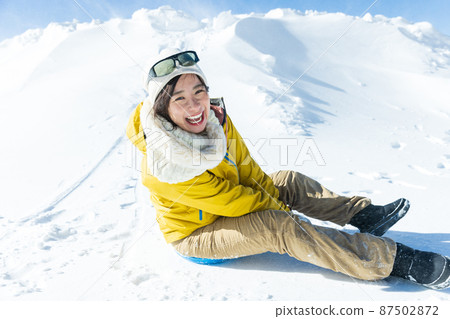 Cute woman enjoying sledding 87502872