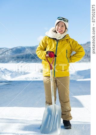 Woman standing with a shovel Woman standing with a shovel 87502875