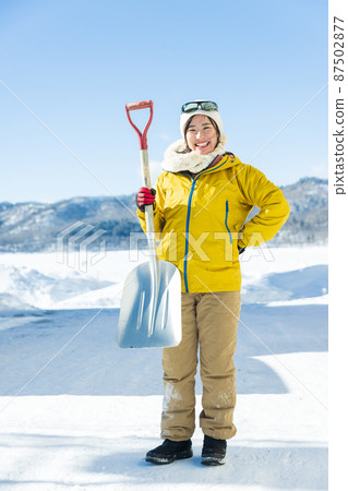 Woman standing with a shovel Woman standing with a shovel 87502877