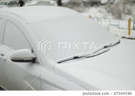 Car is in snow. Icy vehicles. In winter in parking lot. This car is after precipitation. Car is in snow. Icy vehicles. In winter in parking lot. This car is after precipitation. 87504596
