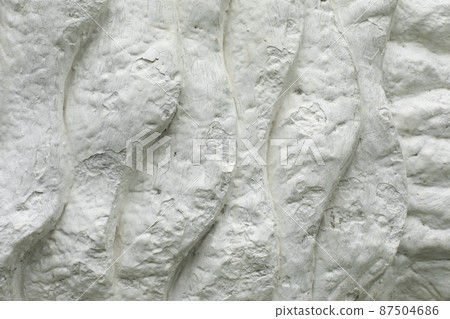 Texture is white. Details of sculpture. Whitewashed surface. Background is made of clumps. Texture is white. Details of sculpture. Whitewashed surface. Background is made of clumps. 87504686