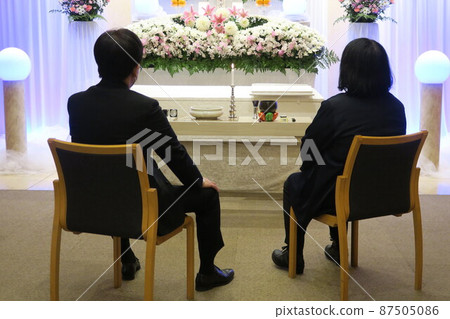 Bereaved family staring at the altar 87505086