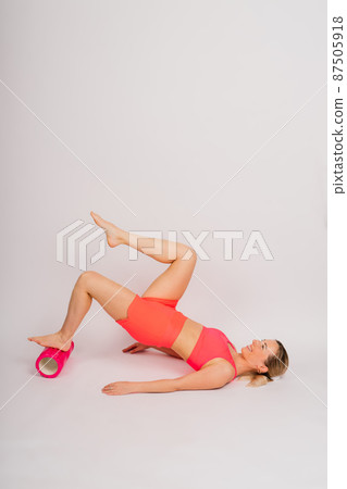 Beautiful female with dumbbells posing on studio background 87505918