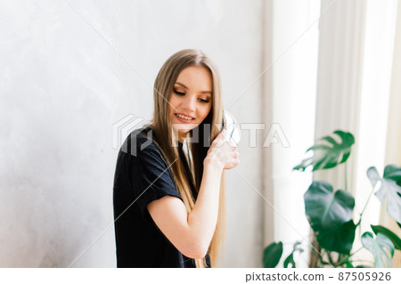 Young woman with long legs and long hair posing on the sofa in a cozy apartment in the morning Young woman with long legs and long hair posing on the sofa in a cozy apartment in the morning 87505926