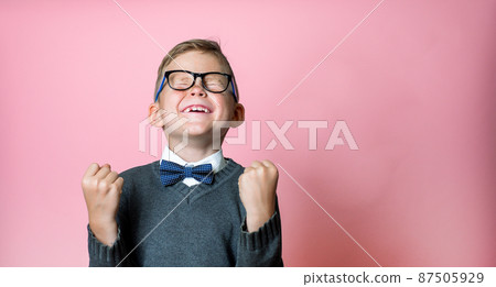 Kid won. Winning success happy boy. School winner. Dynamic image of child with raised hands on pink background. Victory, delight concept. Human facial emotions concept. Trendy colors Kid won. Winning success happy boy. School winner. Dynamic image of child with raised hands on pink background. Victory, delight concept. Human facial emotions concept. Trendy colors 87505929