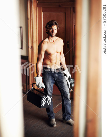 Where would you like me to start. Attractive young handyman standing shirtless while holding his tools. Where would you like me to start. Attractive young handyman standing shirtless while holding his tools. 87506291