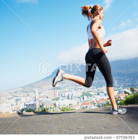 Cross country. Shot of a sporty young woman going for a run outdoors. Cross country. Shot of a sporty young woman going for a run outdoors. 87506363