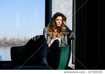 Relaxed woman sit in armchair at home 87506595