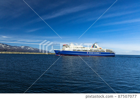 [Niigata Prefecture] Ryotsu Port and Osado Mountains in early spring welcoming passenger ships 87507077
