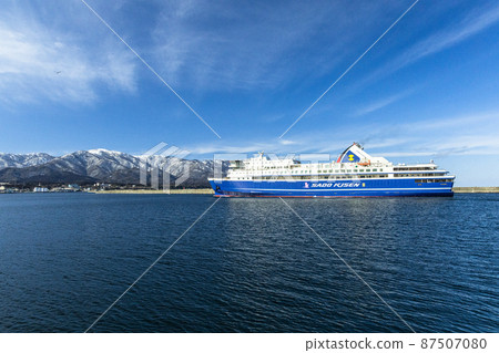 [Niigata Prefecture] Ryotsu Port and Osado Mountains in early spring welcoming passenger ships 87507080